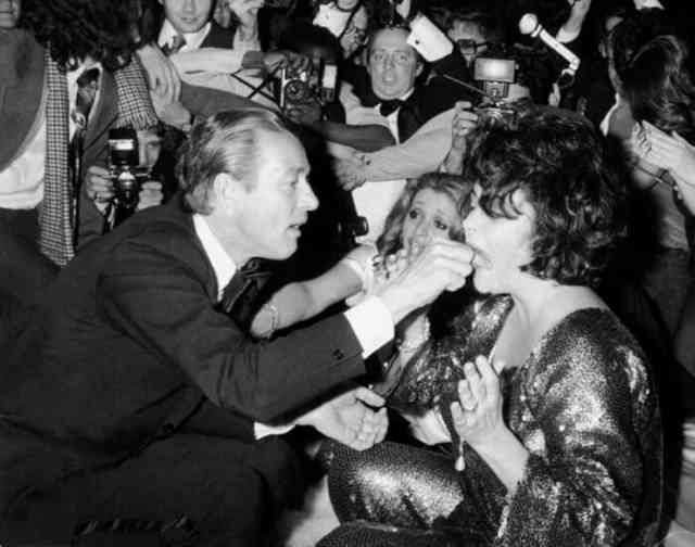 With an opius amount of alcohol and drugs flowing through the club, oddities were bound to occur. Here is design Ray Halston feeding Elizabeth Taylor.