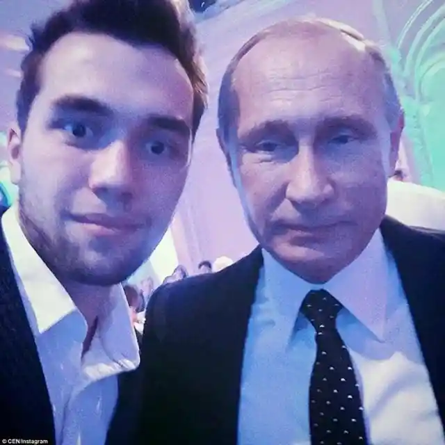 A young man is photographed next to Russian President Vladimir Putin at a black tie event