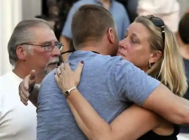 Mourners embrace after a vigil for Vanessa Marcotte