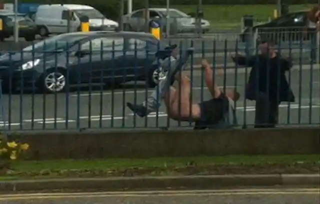 Man with jeans stuck on railings