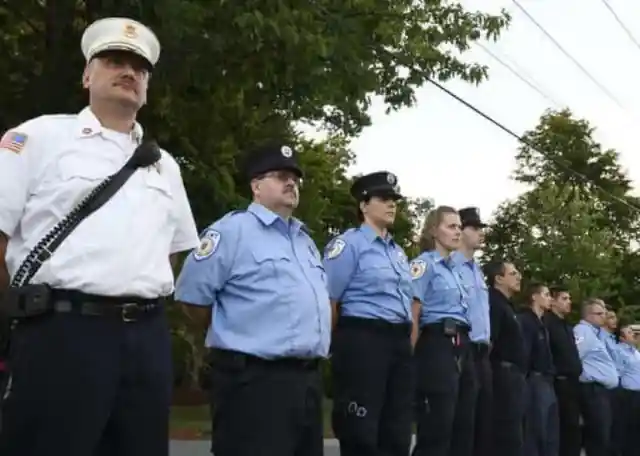 Volunteer fire department personnel stand outside the church during the vigil for Vanessa Marcotte