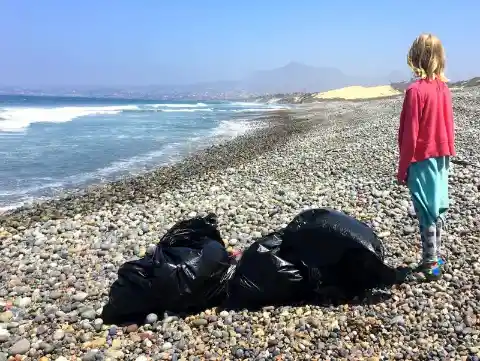 Boy Cleans Up Beach Filled With Trash When He Spots A Strange Bottle