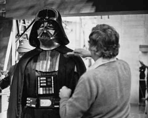 A costume designer puts the finishing touches on Darth Vader's outfit.