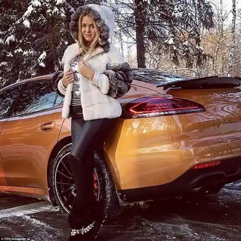 A young girl poses next her gold-coloured Porsche