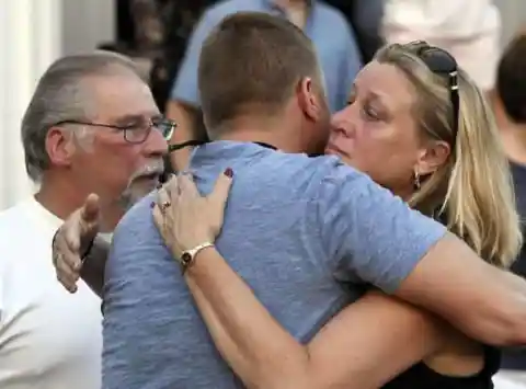Mourners embrace after a vigil for Vanessa Marcotte