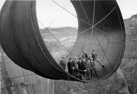 24. Men stand in a 45,000 ton steel pipe over the Hoover Dam.